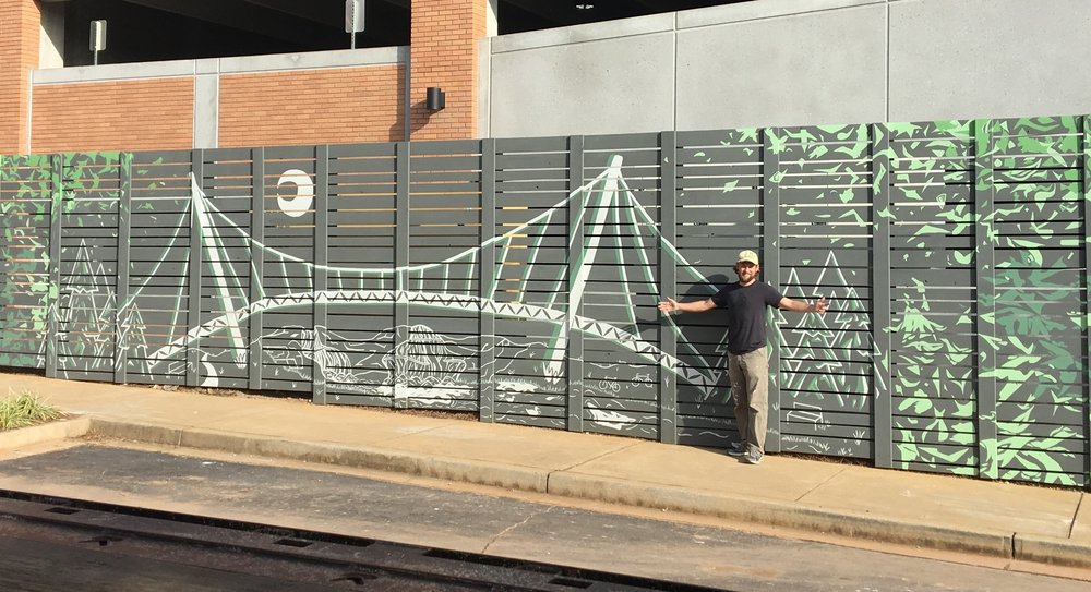 Douglas Piper with his Falls Park mural at 200 East Broad Street