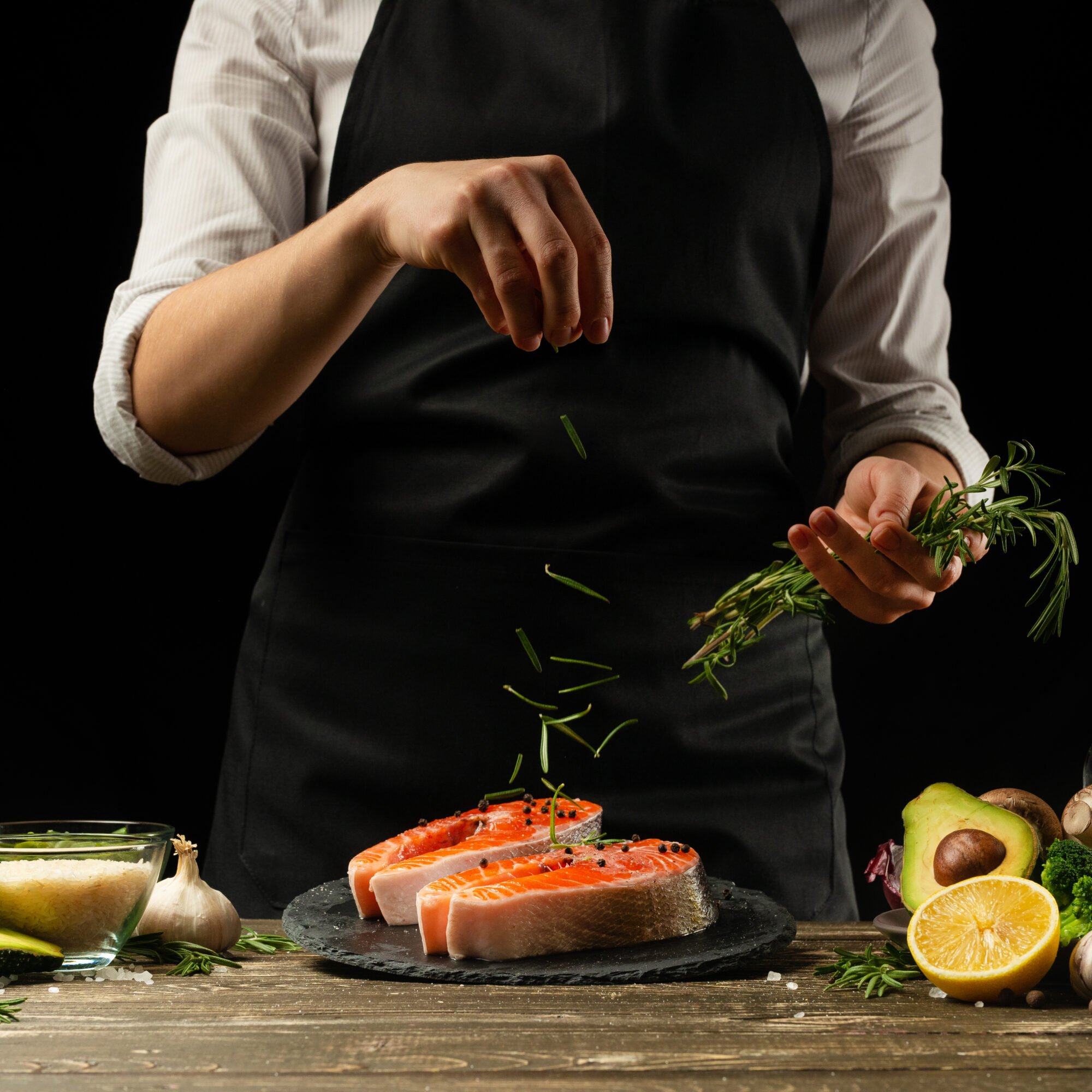 The chef prepares fresh salmon fish, freshly salted trout, sprinkled with rosemary leaves with ingredients. Salmon steak, restaurants, hotel business, menu and recipe book