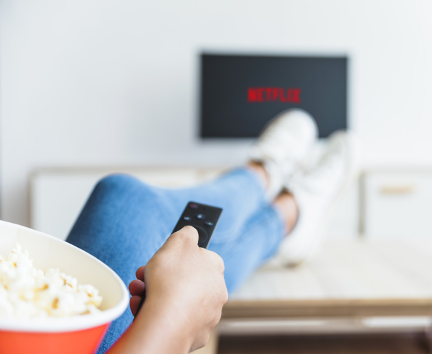 crop-woman-with-popcorn-using-remote-control-tv_23-2147930721